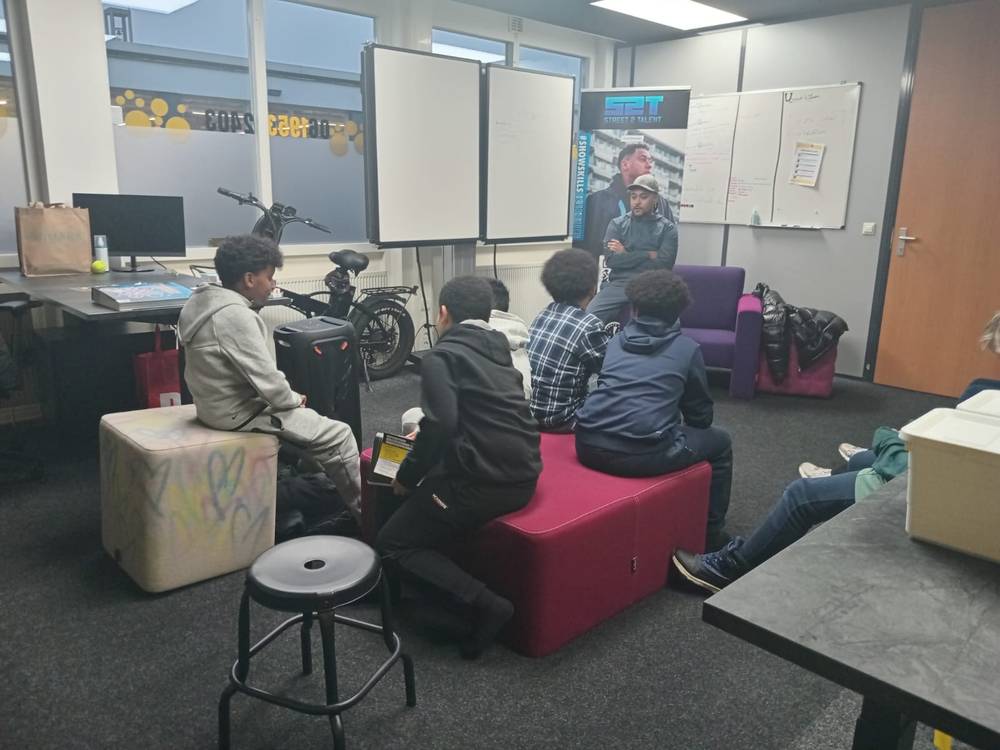 Kleine groep jongeren in gesprek met een jongerenwerker
